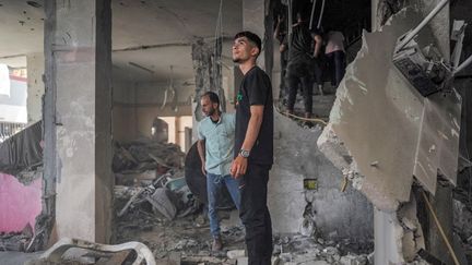 Des habitants de Nuseirat, situé dans le centre de la bande de Gaza, au milieu d'un bâtiment détruit par l'armée israélienne, le 29 avril 2024.. (AFP)