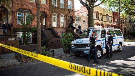 Des policiers montent la garde devant l'entr&eacute;e du domicile de la m&egrave;re de l'auteur de la tuerie de Washington, le 17 septembre 2013 &agrave; New York (Etats-Unis). (ANDREW BURTON / GETTY IMAGES NORTH AMERICA / AFP)