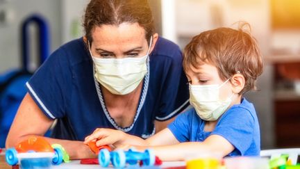 Un enfant joue avec une puéricultrice en pleine épidémie de Covid-19, aux Etats-Unis, le 19 mars 2020.&nbsp; (JUANMONINO / E+ / GETTY IMAGES)