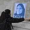 Une manifestante appose sur un mur une affiche de Zineb Redouane à Marseille, le 5 décembre 2020. (NICOLAS TUCAT / AFP)