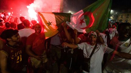 Des supporters de l'Algérie célèbrent, avec les drapeaux algériens et sénégalais, la&nbsp;qualification de l'Algérie en finale&nbsp;de la Coupe d'Afrique des Nations (CAN) 2019 contre le Sénégal, à Bordeaux, le 14 juillet 2019. (MEHDI FEDOUACH / AFP)