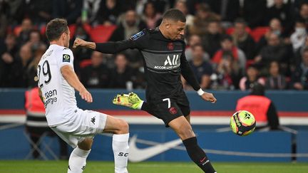 Kylian Mbappé face à Vincent Manceau lors de la 10e journée de Ligue 1 opposant le PSG à Angers, le 15 octobre 2021 au Parc des Princes. (ANNE-CHRISTINE POUJOULAT / AFP)