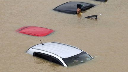 Un homme se d&eacute;m&egrave;ne pour sortir de son v&eacute;hicule cern&eacute; par les eaux &agrave; S&eacute;oul (Cor&eacute;e du Sud), le 22 juillet 2013. (AHN YOUNG-JOON / AP / SIPA)