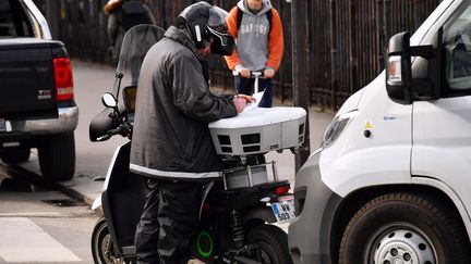 Un salarié de la société Streeteo dresse une contravention à Paris, le 21 mars 2018. (CHRISTOPHE SIMON / AFP)