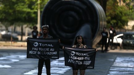 Des militants de Greenpeace protestent contre le projet de forage de Total au large de la Guyane et d'un récif corallien découvert dans l'embouchure de l'Amazone, le 28 septembre 2017, à Rio de Janeiro (Brésil).&nbsp; (PILAR OLIVARES / REUTERS)