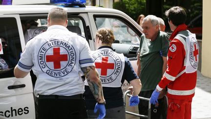 Le personnel de la Croix-Rouge aide un homme handicapé, évacué de Mykolaïv, à Odessa, en Ukraine, le 14 mai 2022. (STR / NURPHOTO / AFP)