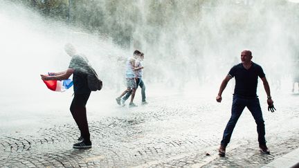 Des manifestants anti-pass sanitaire, le 24 juillet 2021 sur les Champs-Elysées à Paris. (CHRISTOPHE MICHEL / HANS LUCAS / A FP)