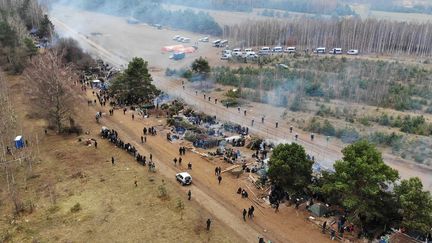 Des migrants à la frontière entre la Biélorussie et la Pologne, le 15 novembre 2021 près de Grodno (Biélorussie). (LEONID SHCHEGLOV / BELTA VIA AFP)