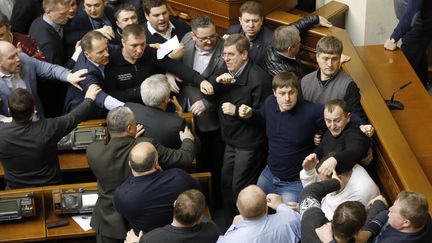 A l'int&eacute;rieur du Parlement aussi la tension est palpable. Des d&eacute;put&eacute;s en sont venus aux mains. Pour la premi&egrave;re fois, les parlementaires ont&nbsp;r&eacute;ussi &agrave; former une majorit&eacute; anti-Ianoukovitch qui&nbsp;a vot&eacute; dans la soir&eacute;e de jeudi une r&eacute;solution revenant sur les mesures antiterroristes annonc&eacute;es la veille par les services sp&eacute;ciaux et ordonnant le retour des soldats dans leurs casernes. (MAKSYM MARUSENKO / AFP)