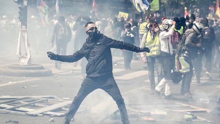 Un manifestant lance un projectile sur les forces de l'ordre avant le départ du cortège syndical à Paris, le 1er mai 2019.&nbsp; (ZAKARIA ABDELKAFI / AFP)