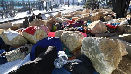 Des migrants tentent de dormir&nbsp;sous le pont de la porte de la Chapelle, dans le 18e arrondissement de Paris, le 15 février 2017. (ALAIN JOCARD / AFP)