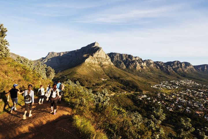 Des touristes randonnent dans parc de Table Mountain Park, en Afrique du Sud. Gérer l'affluence des promeneurs est une problématique&nbsp;que connaît également le parc national de La Réunion. (CHRISTIAN KOBER / ROBERT HARDING HERITAGE)