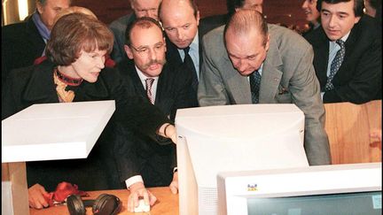 Le président de la République Jacques Chirac, entouré à sa droite de Jacques Toubon, ministre de la Justice et à sa gauche de Philippe Douste-Blazy, ministre de la Culture, de Danielle Mitterrand, face à un ordinateur, à la Bibliothèque nationale de France, le 18 décembre 1996. Photo d'illustration. (GERARD FOUET / AFP)