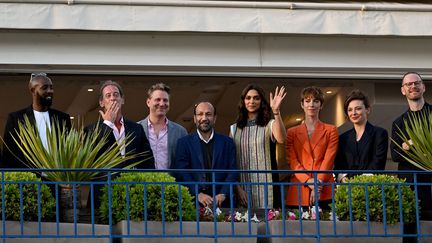 Le président du jury du festival de Cannes Vincent Lindon envoie des baisers depuis le balcon de l'Hôtel Martinez, entouré des membres du jury, de gauche à droite Ladj Ly, Jeff Nichols, Asghar Farhadi, Deepika Padukone, Rebecca Hall, Jasmine Trinca et Joachim Trier (16 mai 2022) (CHRISTOPHE SIMON / AFP)