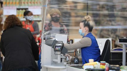 Une caissière portant un masque à la caisse d'un supermarché, à&nbsp;La Ville-du-Bois (Essonne), le 7 mai 2020. (ARNAUD JOURNOIS / MAXPPP)