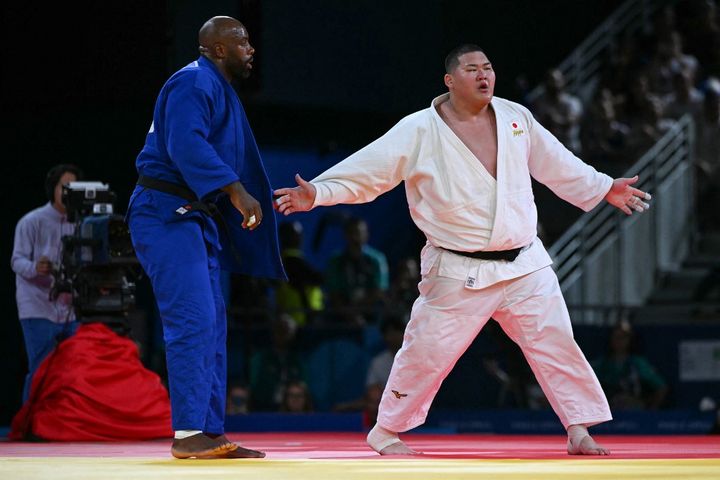 A 3-3, le tirage au sort doit désigner un nouveau combat, forcément un remake de l'un de ceux qui viennent d'avoir lieu. Tatsuru Saito et Teddy Riner sont désignés. Si le premier combat fut intense, que dire du second ? La tension est omniprésente, la fatigue terrible pour les deux judokas, qui écopent chacun de deux pénalités. (LUIS ROBAYO / AFP)