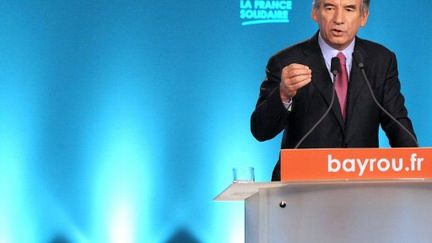 Derrière François Bayrou, son nouveau slogan de campagne (MEHDI FEDOUACH / AFP)