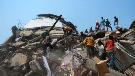 Des sauveteurs et des volontaires lors d'opérations de secours après l'effondrement d'un immeuble qui a fait des centaines de morts à Dacca, le 26 avril 2013.   (AFP/MUNIR UZ ZAMAN)