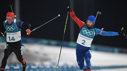 Martin Fourcade et Simon Schempp franchissent la ligne d'arrivée de la mass start, à Pyeongchang le 18 février 2018. (FRANCK FIFE / AFP)