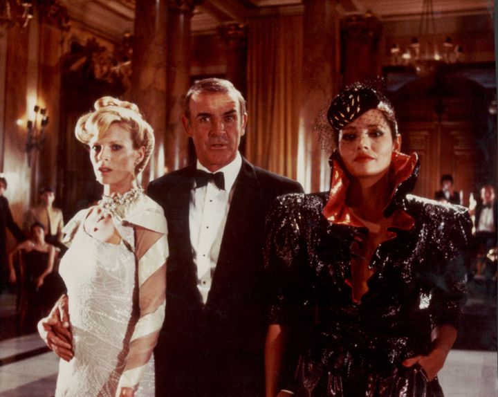 L'acteur Sean Connery, dans le rôle de James Bond, entouré des actrices Kim Basinger et Barbara Carrera, sur le tournage du film "Jamais plus jamais", en 1983. (STANLEY BIELECKI MOVIE COLLECTIO / MOVIEPIX)