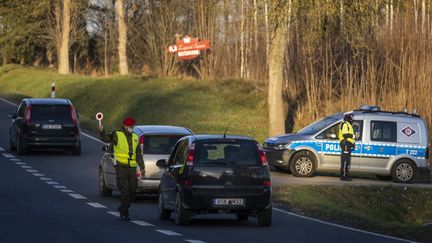 Des policiers et militaires polonais contrôlent des véhicules entre Sokolka et Kuznica (Pologne), le 10 novembre 2021. (WOJTEK RADWANSKI / AFP)