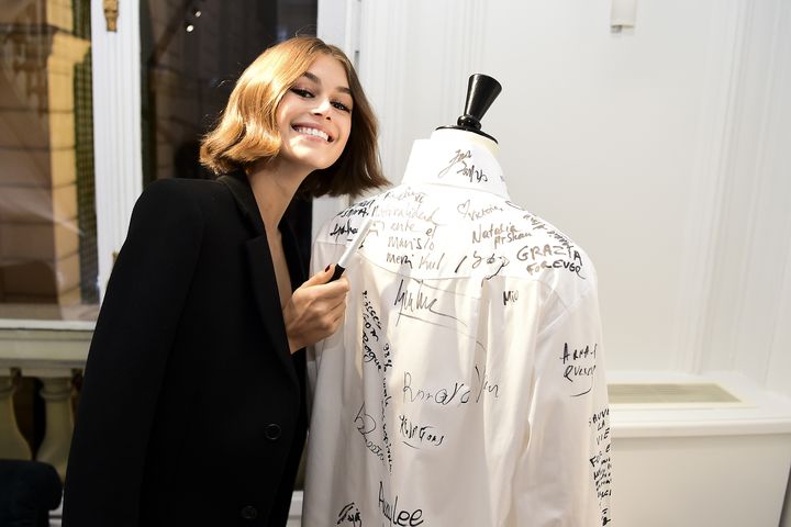 La mannequin Kaia Gerber dédicace une chemise blanche lors de l'exposition "A Tribute to Karl Lagerfeld" à Paris, le 25 septembre 2019 (ANTHONY GHNASSIA / GETTY IMAGES EUROPE)