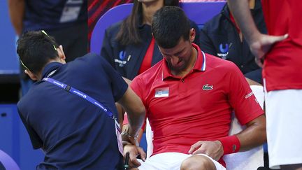 Souffrant du poignet, Novak Djokovic est massé par le médecin lors de son match contre Alex de Minaur, en United Cup à Perth (Australie), le 3 janvier 2024. (TREVOR COLLENS / SIPA)