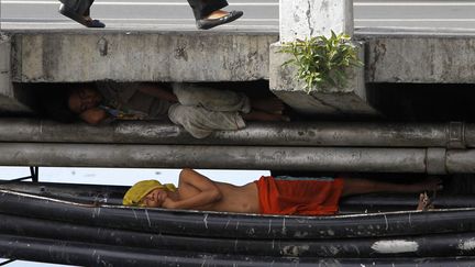 Un enfant des rues dort sous un pont &agrave; Paranaque (Philippines), le 18 juillet 2013. (ROMEO RANOCCO / REUTERS)