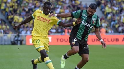 Dennis Appiah et Facundo Medina lors de Nantes-Lens en Ligue 1, le 18 septembre 2022. (SEBASTIEN SALOM-GOMIS / AFP)