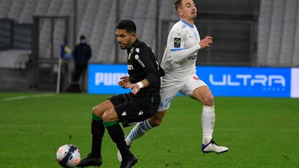 Le milieu de terrain de l'OM Valentin Rongier passe le Lensois Facundo Medina au Vélodrome le 20 janvier 2021 (NICOLAS TUCAT / AFP)