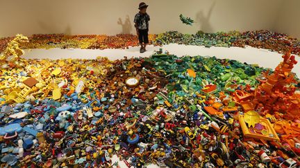 Un jeune gar&ccedil;on observe l'installation, con&ccedil;ue avec plus de 10 000 jouets abandonn&eacute;s, imagin&eacute;e par l'artiste japonais Hiroshi Fuji &agrave; Tokyo (Japon), le 6 septembre 2012. (KIM KYUNG HOON / REUTERS)