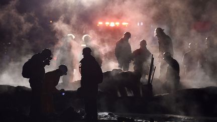 Des pompiers éteignent les braises après l'explosion d'un oléoduc percé par des voleurs de carburant, samedi 19 janvier 2019 à&nbsp;Tlahuelilpan (Mexique). (ALFREDO ESTRELLA / AFP)