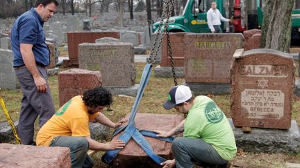 Des personnes cherchent à redresser une stèle juive, après des actes de vandalisme au cimetière de&nbsp;Chesed Shel Emeth, près de Saint-Louis dans le Missouri (Etats-Unis), le 21 février 2017.&nbsp; (TOM GANNAM / REUTERS)