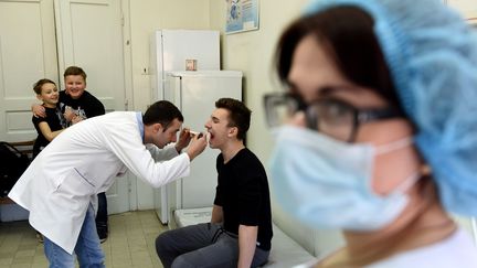 Un médecin examine un adolescent avant une vaccination contre la rougeole, le 19 février 2019 à Lviv (Ukraine). (YURI DYACHYSHYN / AFP)