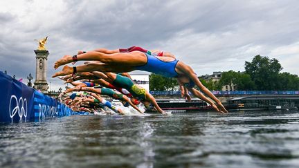 Les triathlètes plongent dans la Seine à Paris le 31 juillet 2024, lors de l'épreuve féminine individuelle des Jeux olympiques. (MARTIN BUREAU / AFP)