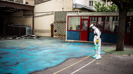 Un agent décontamine la cour d'une école du 1er arrondissement de Paris, le 8 août 2019. (MARTIN BUREAU / AFP)