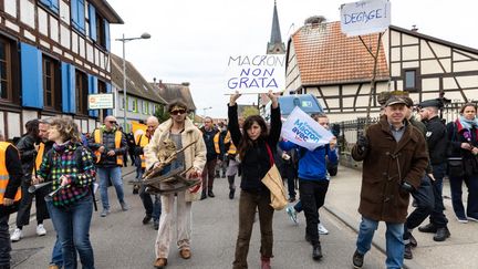 Des manifestants expriment leur opposition à la réforme des retraites lors d'un déplacement d'Emmanuel Macron à Muttersholtz (Bas-Rhin), le 19 avril 2023. (ABDESSLAM MIRDASS / HANS LUCAS / AFP)