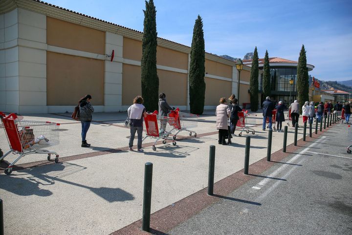 Des clients font la queue devant un supermarché, à Valence (Drôme), le 27 mars 2020.&nbsp; (NICOLAS GUYONNET / HANS LUCAS / AFP)