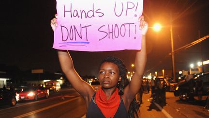 Une manifestante brandit une pancarte "Mains en l'air ! Ne tirez pas !", le 17 ao&ucirc;t 2014. (MICHAEL B. THOMAS / AFP)