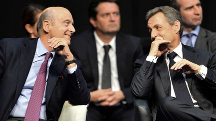 Alain Juppé et Nicolas Sarkozy, le 14 octobre 2015, à Limoges (Haute-Vienne), lors d'un meeting pour les régionales. (NICOLAS TUCAT / AFP)