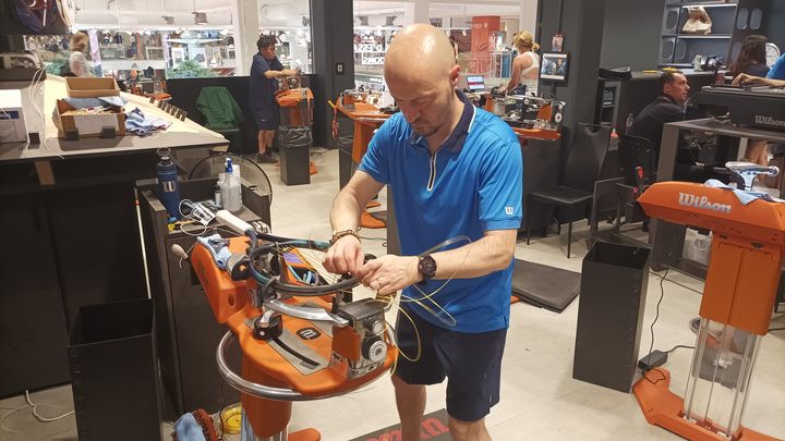 Gaël Chevalier en plein travail pour corder la raquette de Daniel Altmaier, le 1er juin 2023, à Roland-Garros. (Emmanuel Rupied / Franceinfo :sport)