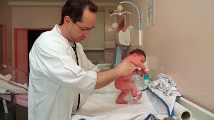 Un p&eacute;diatre examine un nouveau-n&eacute; le 5 juin 2001 au service maternit&eacute; de l'h&ocirc;pital franco-britannique de Levallois-Perret (Hauts-de-Seine). (DIDIER PALLAGES / AFP)