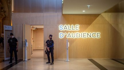 Des policiers se tiennent devant une salle d'audience du tribunal de Paris, le 6 septembre 2021. (CARINE SCHMITT / HANS LUCAS / AFP)