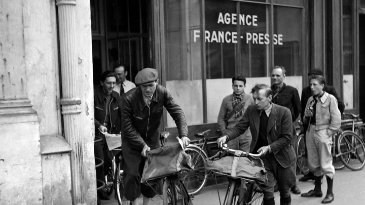 Des livreurs quittent l'immeuble de l'Agence France Presse, place de la Bourse à Paris, en 1950. (AFP)