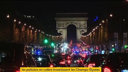 Des policiers manifestent en voiture sur les Champs-Elysées, dans la nuit du 17 au 18 octobre 2016. (FRANCEINFO)