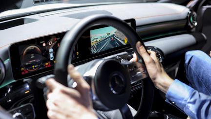 Un parlementaire américain teste une voiture de course Mercedes Benz, durant le Mondial de l'automobile à Barcelone (Espagne), le 25 février 2019. (JOAN CROS / NURPHOTO / AFP)