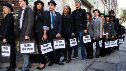 Des jeunes anglais participent &agrave; une action devant un centre pour l'emploi &agrave; Londres afin d'attirer l'attention sur le ch&ocirc;mage des jeunes, le 10 octobre 2011. (LEON NEAL / AFP)