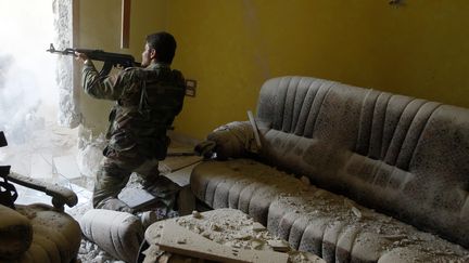 Un membre de l'Arm&eacute;e syrienne libre (opposition) tire depuis un appartement d'Alep (Syrie) le 14 ao&ucirc;t 2012. (GORAN TOMASEVIC / REUTERS)