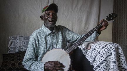 Giddes Chalamanda, 92 ans, joue de son banjo acoustique chez lui dans le village de Madzuwa près de Chiradzulu, dans le sud du Malawi, le 13 janvier 2022. (AMOS GUMULIRA / AFP)
