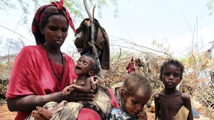 Une mère de famille sous-alimentée portant son bébé dans un camp temporaire à Mogadiscio, capitale de la Somalie, le 26 août 2011, alors que le pays était touché par une très importante sécheresse.